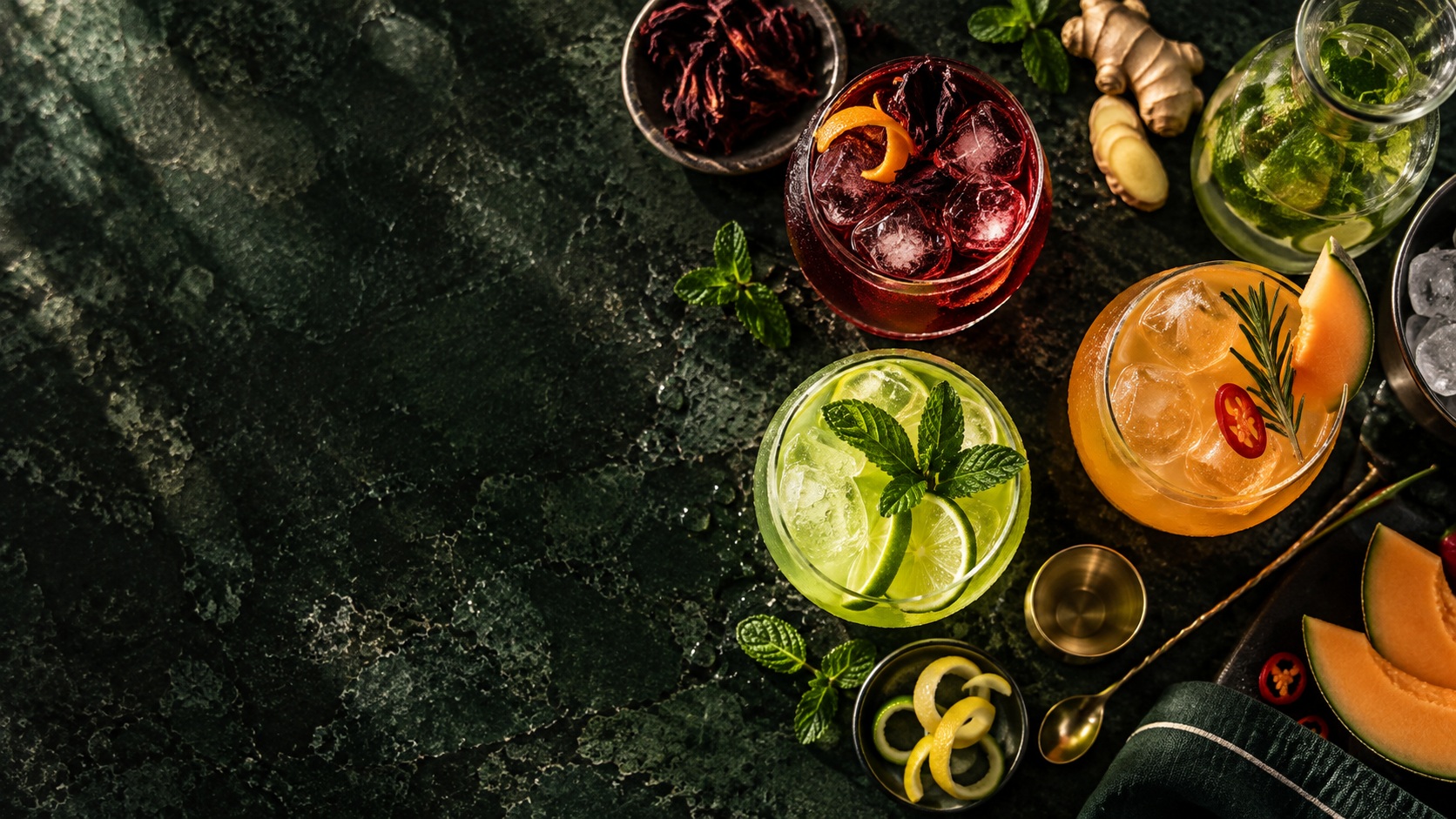 Colourful botanical refreshments with citrus, herbs and ingredients viewed from above.